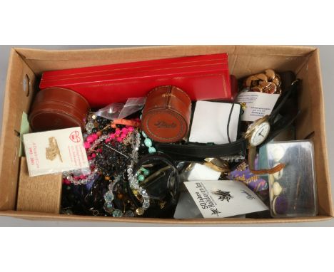 A box of costume jewellery and badges to include manual and quartz wristwatch, beads etc.