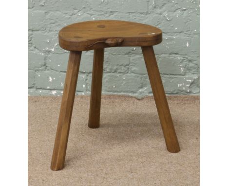 After Robert Mouseman Thompson an oak three legged stool with kidney shape seat.