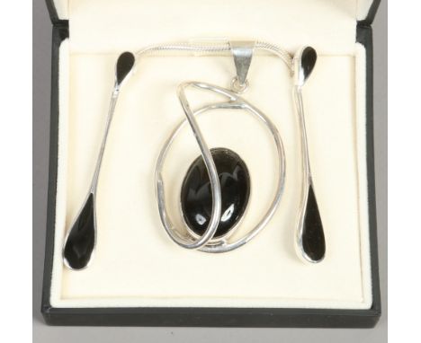 A silver pendant and earring set with black enamel.
