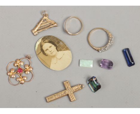 A 9ct gold cross pendant, harp fob charm, red stone openwork pendant, two dress rings and a small quantity of loose gems.