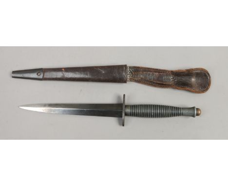 A World War II Faibairn Sykes fighting knife in leather scabbard, stamped 3 to the handle.