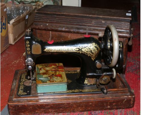 An oak cased Singer sewing machine with instruction manual and accessories.