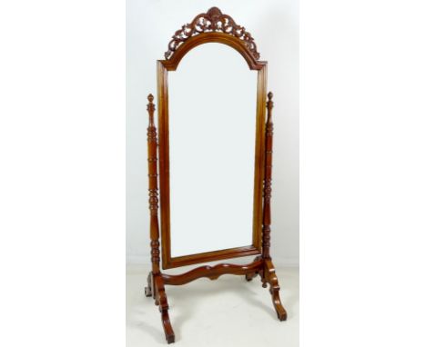A modern mahogany cheval mirror, with carved crest and ring turned supports, 82 by 60 by 190cm high.