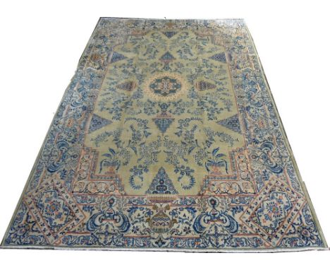 A Kashan rug, blue delicate floral fronds and flower heads arranged in triangles on an unusual light olive green ground, 390 