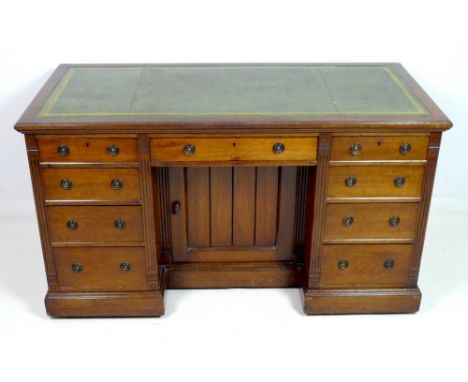 A Victorian mahogany desk, with tooled green leather surface, nine graduating drawers with ring handles, central cupboard wit