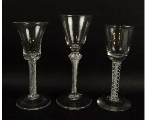 A group of three 18th century wine glasses, with cut pontils and double air twist stems, two with bucket and one with bell sh