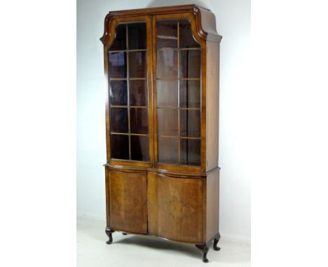 A reproduction Queen Anne style glazed bookcase, circa 1960, with twin astragal glazed doors enclosing four adjustable shelve