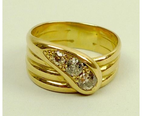 An 18ct gold and diamond ring in the form of a triple coiled snake, with three diamonds to the stylised head, largest diamond