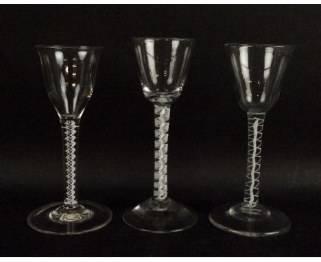 A group of three wine glasses, with double air twist stems and bucket and bell shaped bowls, with cut pontils, 15 and 15.5cm.