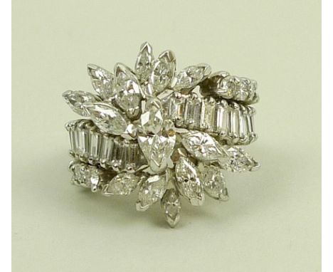 An impressive diamond dress ring, of stylised flower design, with princess cut diamonds, a continuous band of baguette cut di