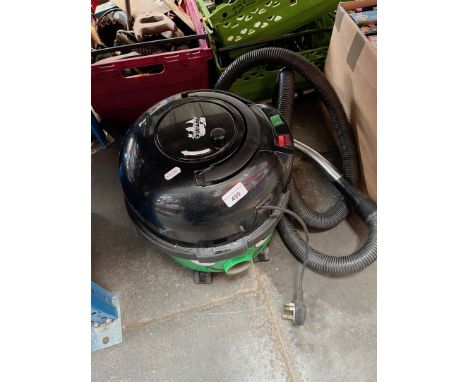 A vintage green Henry vacuum cleaner. 