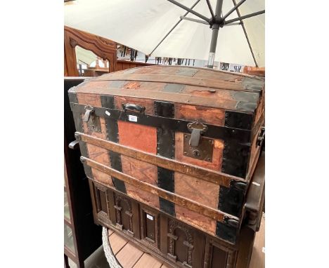 An antique leather and metal bound domed top trunk, circa 1900. 