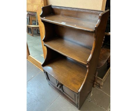 An Ercol dark elm waterfall bookcase. 