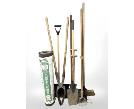 A group of garden tools and a roll of felt roofing.