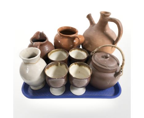 A group of terracotta jugs, teapot, set of four earthenware goblets, etc.
