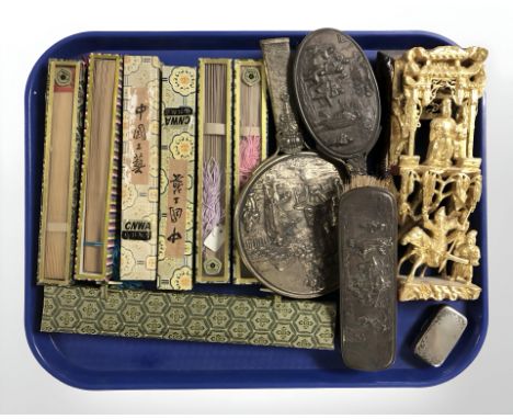 A group of boxed oriental hand fans, continental embossed white metal compact, further dressing table brushes and mirror, an 