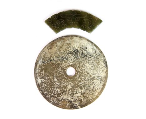 A Chinese Warring States style carved jade pi disc, Dia. 10.5cm and a similar jade curved panel.