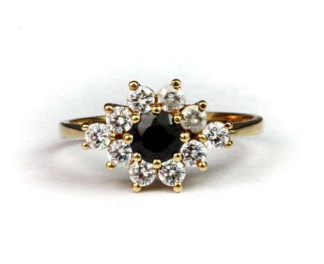 A 9ct yellow gold ring set with a ruby surrounded by white stones, (P.5).