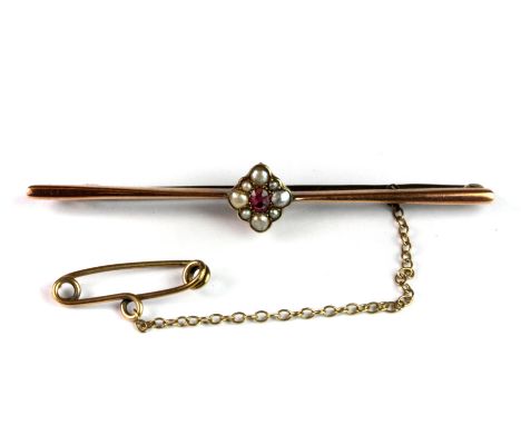 A 9ct rose gold (stamped 9ct) bar brooch set with a ruby and seed pearls, L. 6cm.