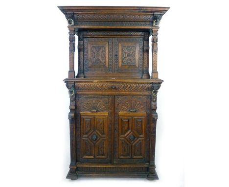 A Victorian Elizabethan Revival oak court cupboard, profusely carved with marks, caryatids and lions heads with brass rings, 