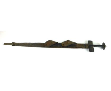 A 19th century Sudanese Tuareg style sword, with leather and brass handle and pommel, leather worked hilt and part scabbard, 