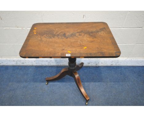 A VICTORIAN FLAME MAHOGANY TILT TOP TRIPOD TABLE, with a turned support, on three shaped legs and brass castors, width 76cm x