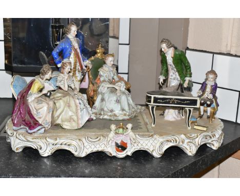 A SITZENDORF PORCELAIN FIGURE GROUP, depicting the six year old Mozart playing piano for a group including Empress Marie Ther