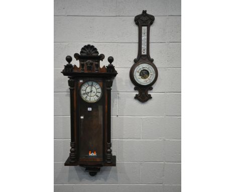 A WALNUT CASED VIENNA WALL CLOCK, with twin finials and central mask, the glazed door enclosing 7 inch dial, depicting Roman 