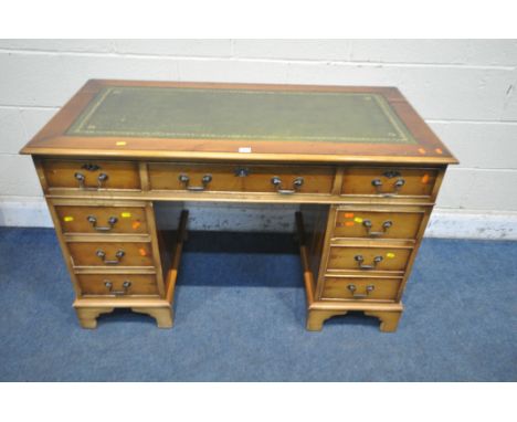 A 20TH CENTURY YEW WOOD TWIN PEDESTAL DESK, with green tooled leather writing surface, fitted with an arrangement of eight dr