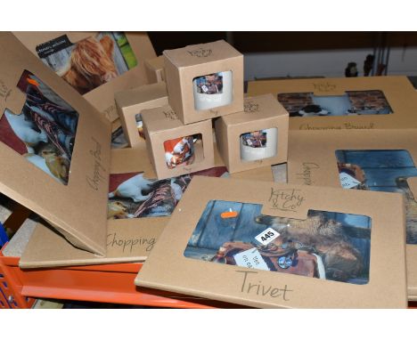 A GROUP OF BOXED NEW AND UNUSED BORDER FINE ARTS 'KITCHY &amp; CO' GLASS CHOPPING BOARDS, TRIVETS AND CERAMIC MUGS, comprisin