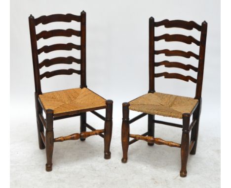 A harlequin set of six 19th century ash and oak wavy ladder back dining chairs with rush seats, turned stretchers and turned 