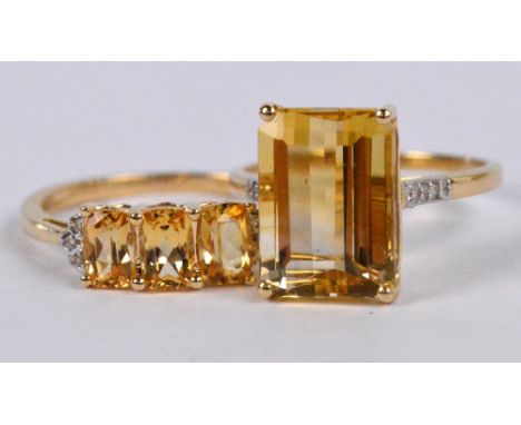 TGGC; a 10ct yellow gold ring set with large radiant cut pale yellow stone flanked by six tiny diamonds to shoulders in high 