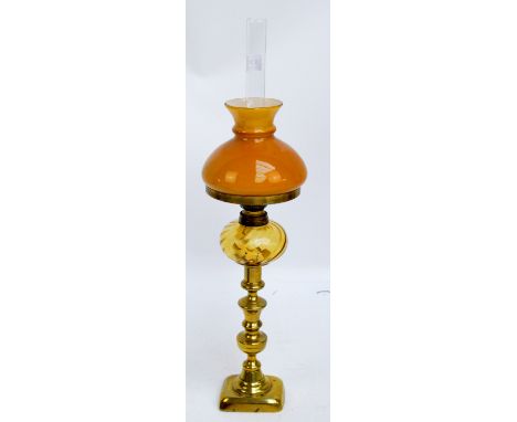 A late Victorian oil lamp with pale peach tinted reservoir, etched shade, and brass column, height 64cm, two further oil lamp