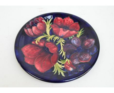 A modern Moorcroft "Anemone" pattern tubeline decorated charger on blue ground, impressed marks to base, dated with a candles