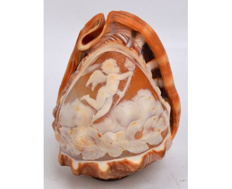 A cameo conch shell lamp shade decorated with a cherub amongst clouds and floral motif, height 14cm.