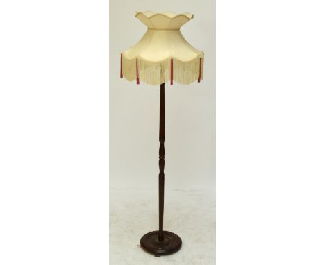 A mahogany standard lamp with baluster decorated tapering stem to circular base, height 148cm excluding fittings.