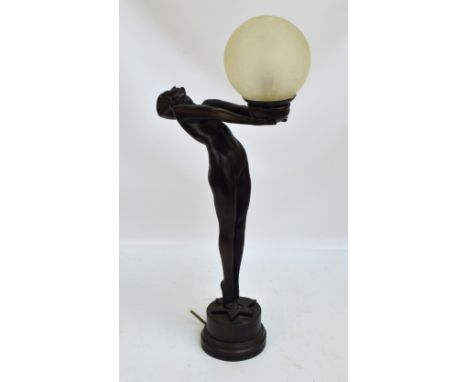 An Art Deco style resin figural table lamp modelled as a female gymnast holding a crackle white opaque globular shade, height