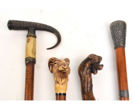 A group of eight various walking sticks and canes to include two antler handled examples, a malacca white metal mounted examp