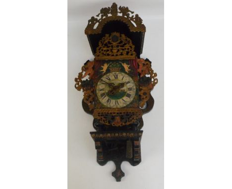 A late 19th century Dutch weight driven wall clock with pierced metal cherub decorated side panels and similarly decorated ha