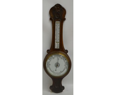 A 1930s carved oak banjo aneroid barometer/thermometer, height 80cm.