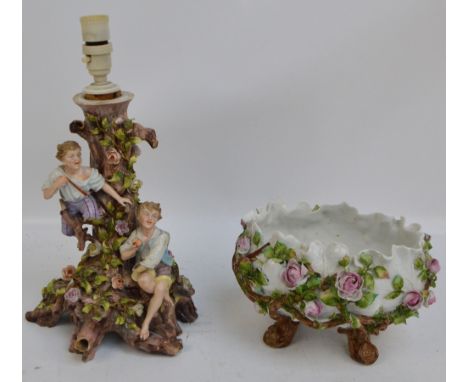 An early 20th century Continental oval porcelain bowl encrusted throughout with roses, leaves and branches and raised on four