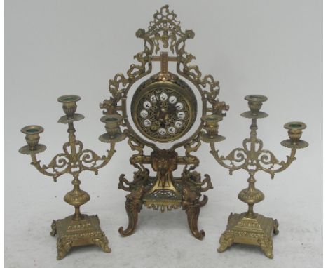 An early 20th century Chinese inspired brass mantel clock with dragon decorated pierced frame, swinging ball movement, and wh
