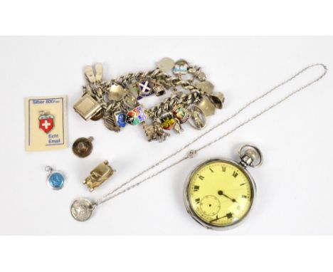 A hallmarked silver curb link charm bracelet suspending numerous predominantly silver charms to include a bible, a cup and sa