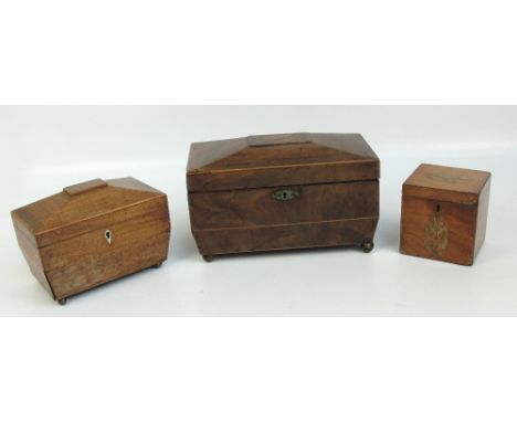 A late 19th/early 20th century mahogany sarcophagus tea caddy centred with a starburst ornament to the hinged lid enclosing i