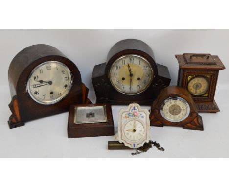 A collection of mantel clocks including an Art Deco style example with arched top, shaped wooden sides, Arabic numerals, a sm