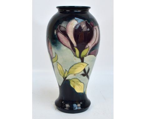 A modern Moorcroft "Magnolia" pattern tubeline decorated baluster vase, impressed marks to base, dated with candlestick for 1