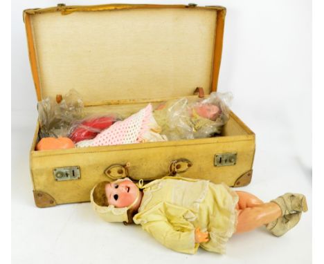 An Armand Marseille bisque headed doll with open close eyes and open mouth revealing four teeth, with red hair, dress and mat