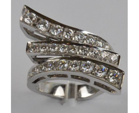 An 18ct white gold diamond set ring of abstract design, the central raised platform flanked by twin further swept pierced pla