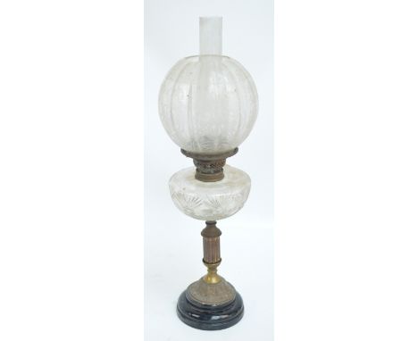 A late 19th/early 20th century oil lamp with clear cut glass reservoir on glass fluted stem with spreading circular foot, wit