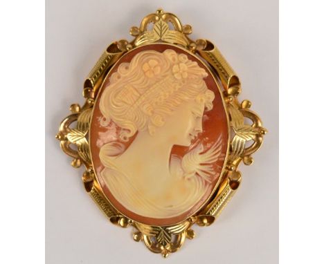A large 9ct gold framed cameo brooch, the oval plaque depicting the profile portrait of a young woman beside a bird within an